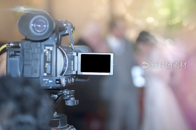 在婚礼上用摄像机拍摄新郎新娘，对焦。