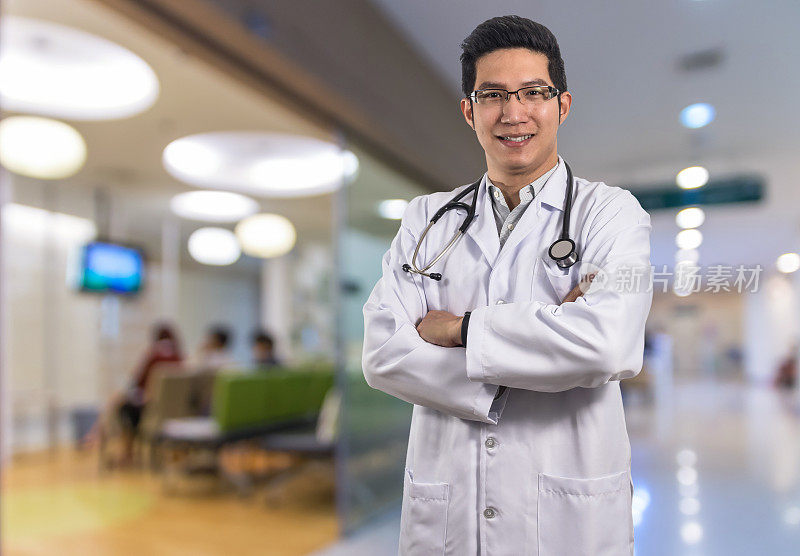 亚洲医生的肖像与听诊器设备在医院背景的抽象照片模糊，病人坐椅与等待座位看医生，医院和医生的概念