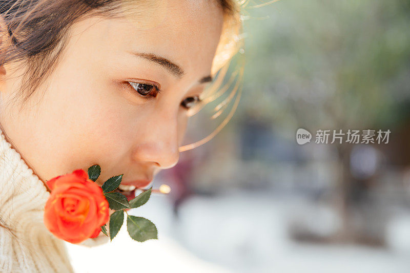 亚洲女孩在太阳耀斑下的红花，上海，中国