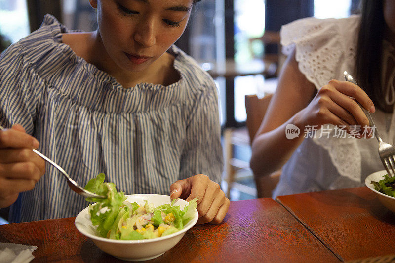 一个正在吃沙拉的女人。