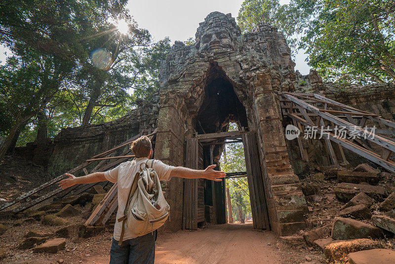 旅人从寺院复杂的大门伸出双臂，感受着旅行的自由和幸福