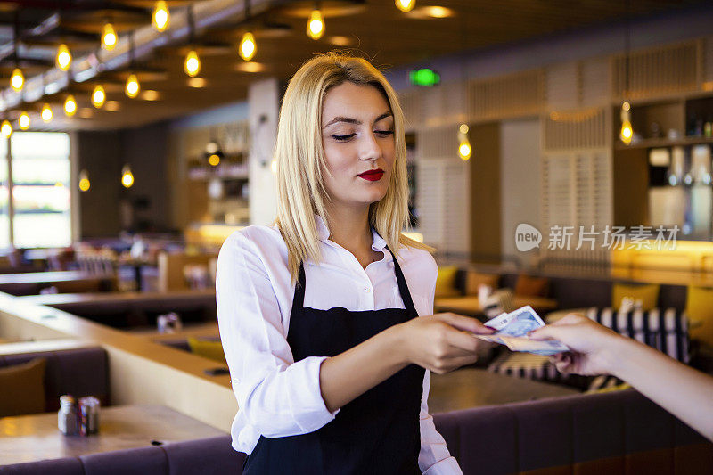 在餐馆做收银员的女人