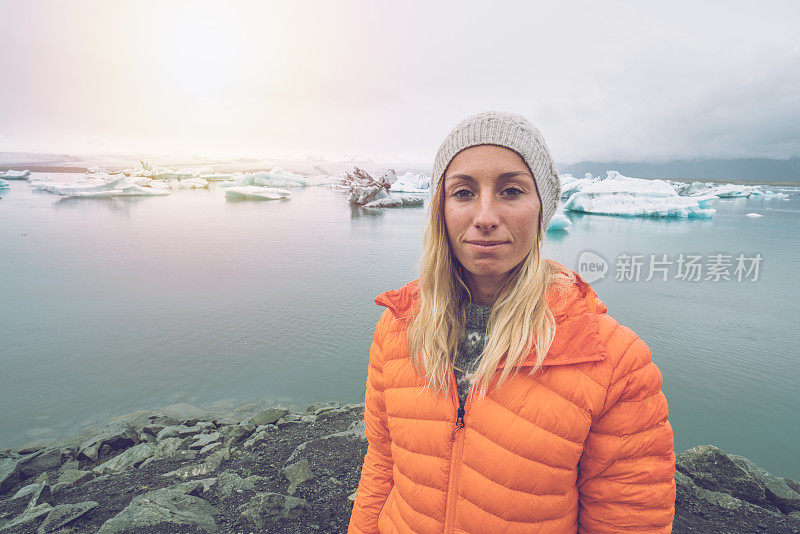 女子肖像站在冰岛冰川泻湖，人们北上旅游发现概念