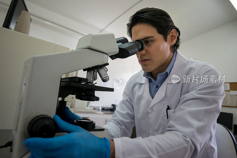 拉丁美洲的微生物学家在实验室用显微镜观察一些样本