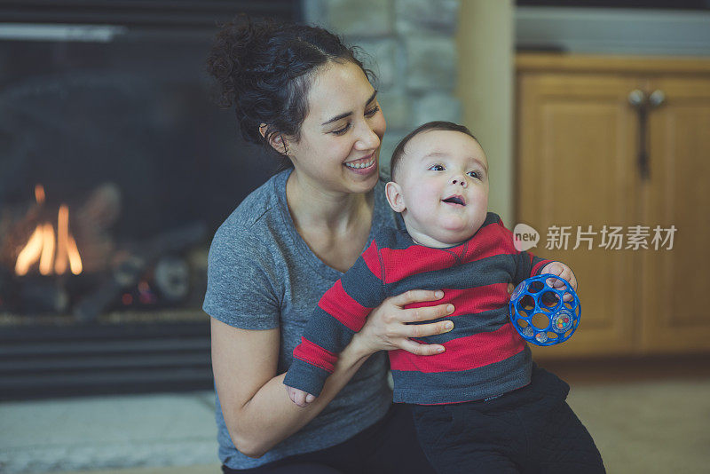 年轻的夏威夷妈妈和她六个月大的儿子在地板上玩耍