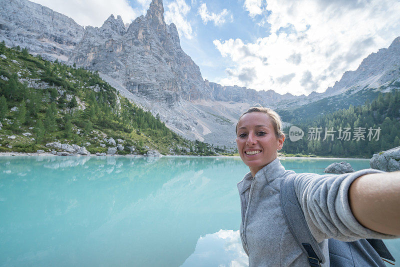 徒步旅行者在阿尔卑斯山湖自拍，意大利