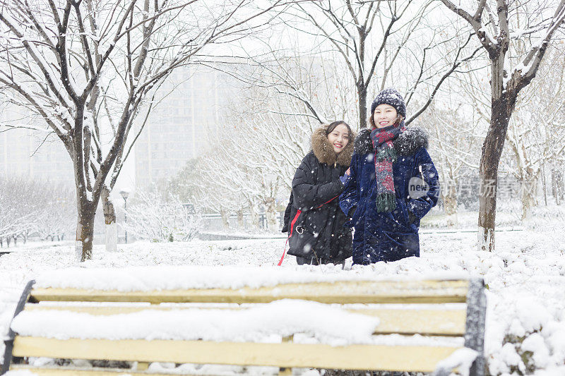 女性朋友穿着暖和的衣服，在雪地里画像