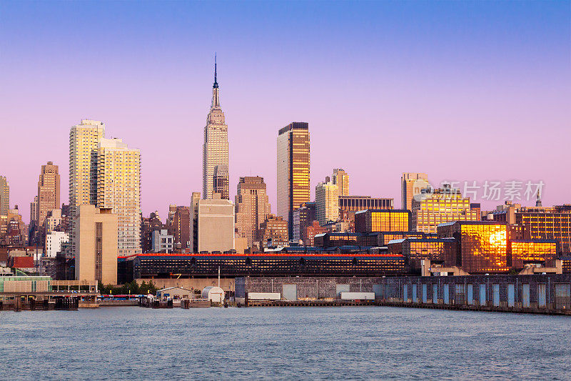 日落时分的纽约城市天际线，帝国大厦，曼哈顿摩天大楼和哈德逊河。