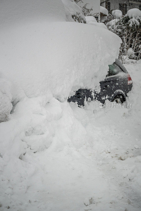 在德国巴伐利亚阿尔卑斯山的一条寒冷的道路上，一辆被雪覆盖的汽车。灾难预警
