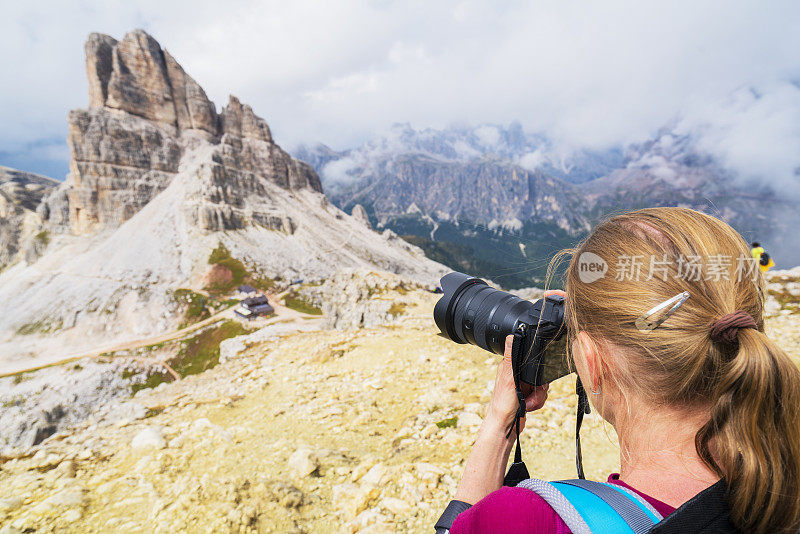 后视图肖像的年长妇女拍照的萨斯迪斯特里亚峰在Averau-Nuvolau集团在Dolomites，意大利