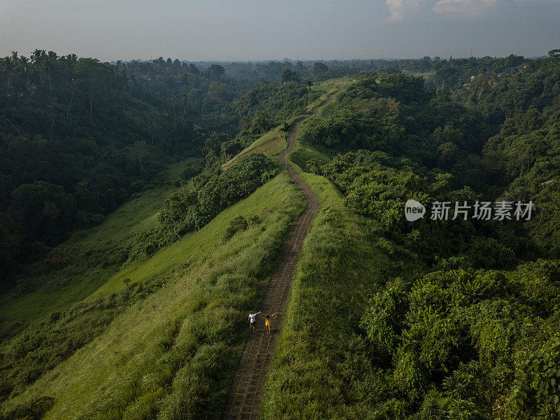 无人机的观点，年轻夫妇走在大米自然散步，乌布-巴厘岛-人们旅游热带目的地爱浪漫的概念