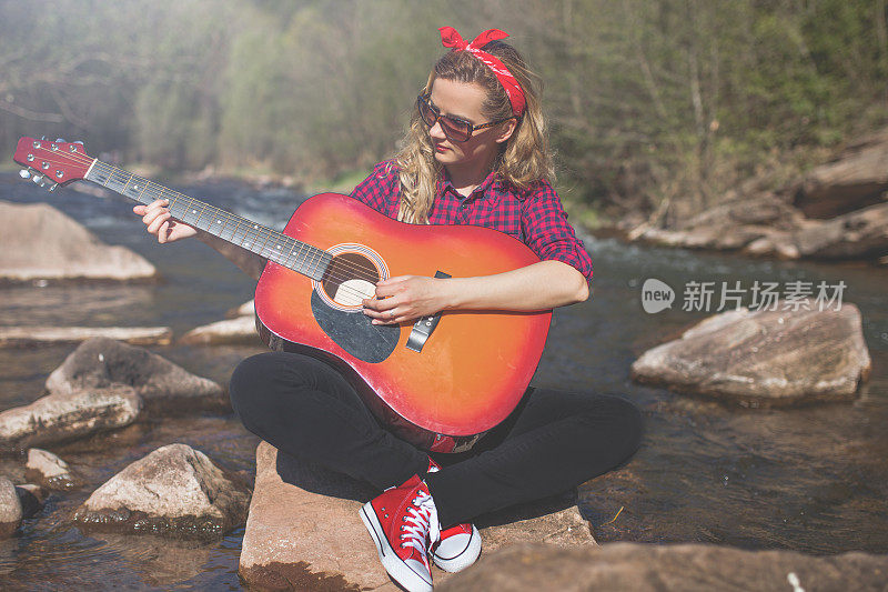 女人在河边弹吉他