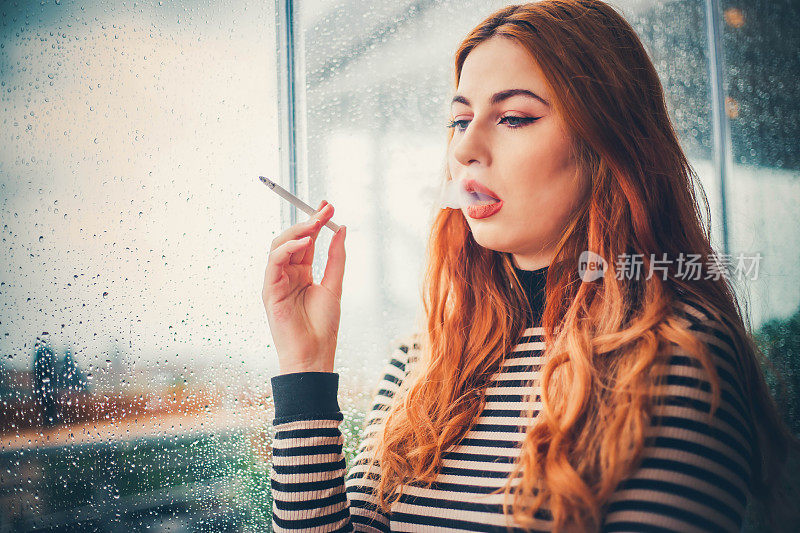 在雨窗后抽烟的女人