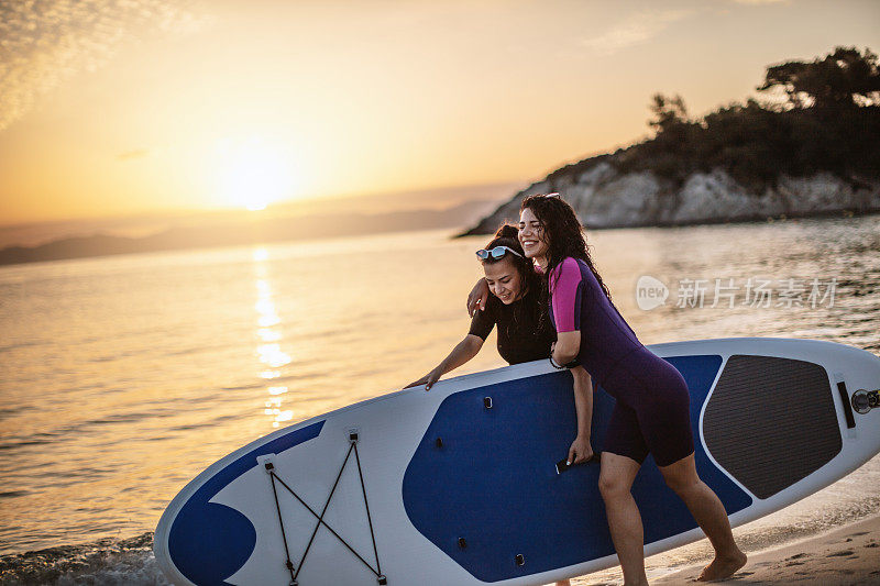 两个女性朋友与桨板
