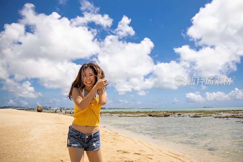 美丽的年轻女子站在度假海滩上