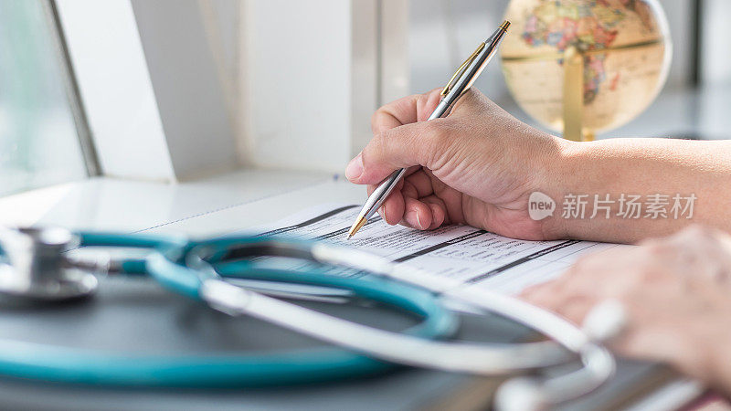 医生医生在医院诊所写医疗保健记录，病人出院，或处方表格