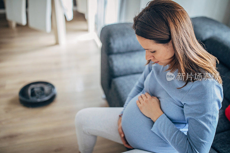 孕妇休息时，机器人真空吸尘器打扫地板