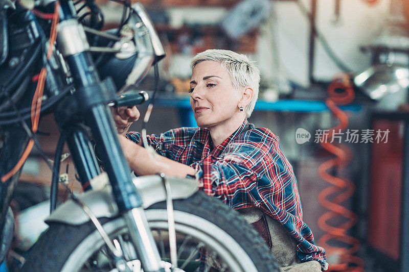 女机械师在修理一辆坏掉的摩托车