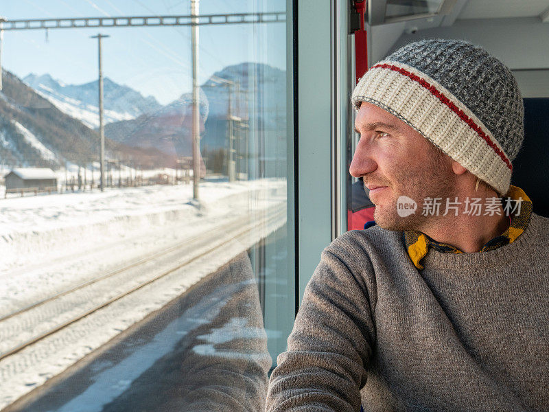 在瑞士乘火车旅行的年轻游客透过窗户看
