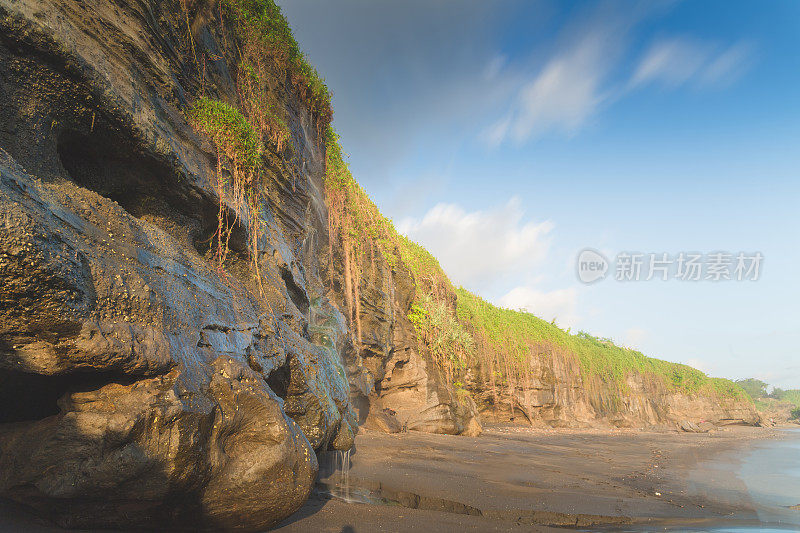 印度尼西亚巴厘岛日落时热带海滩海的宽角视图