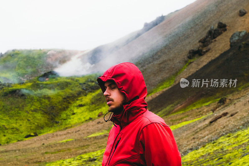 一名游客徒步穿越冰岛风景优美的地热山谷