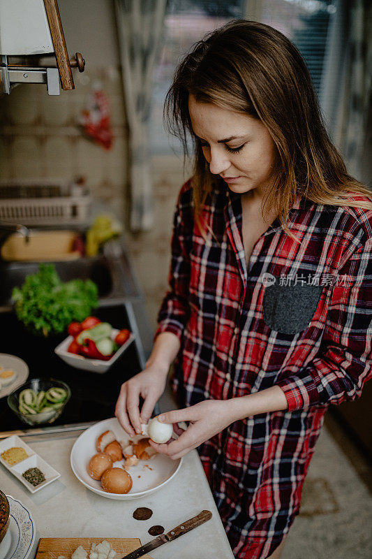 年轻女子在厨房剥鸡蛋