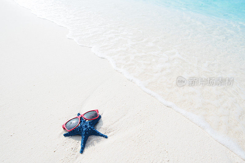 夏日海滩上戴着太阳镜的海星——海滩假日概念