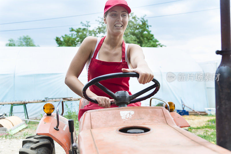 一位年轻的女农民开着拖拉机