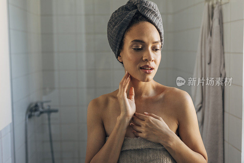 美丽的非洲裔美国女人裹在毛巾洗澡后