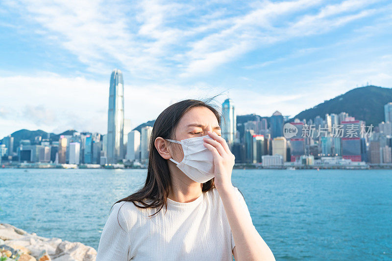 一名年轻的亚洲女子戴着防护口罩，以防止冠状病毒的传播，这是一场全球卫生紧急事件的爆发