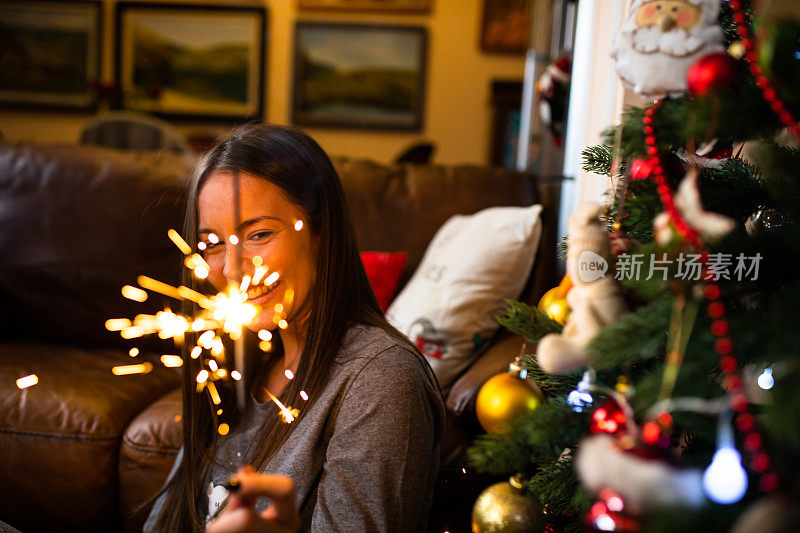 一个年轻的女人拿着熊熊燃烧的烟火