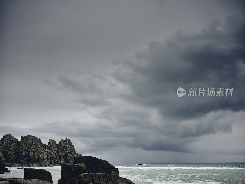 在一个恶劣的秋天天气里，康沃尔的佩顿·范德海滩上，乌云密布，大雨倾盆。