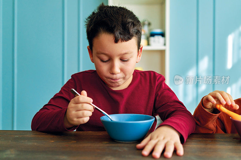 可爱的孩子们早餐吃玉米片和牛奶