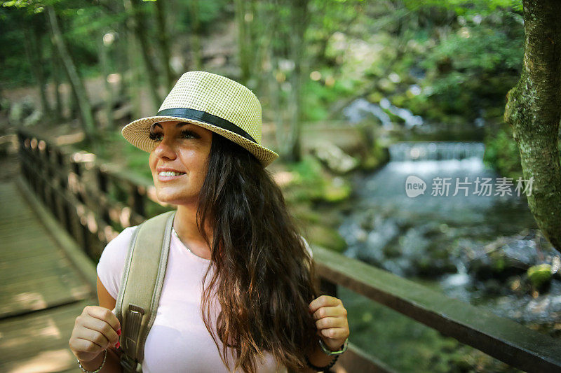 一个年轻的女人在大自然中漫步，享受美好的一天。