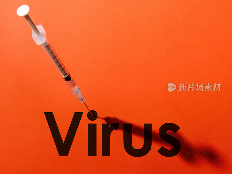 注射器上的针头穿过单词“病毒”(Virus)中字母“i”的圆点的中心。