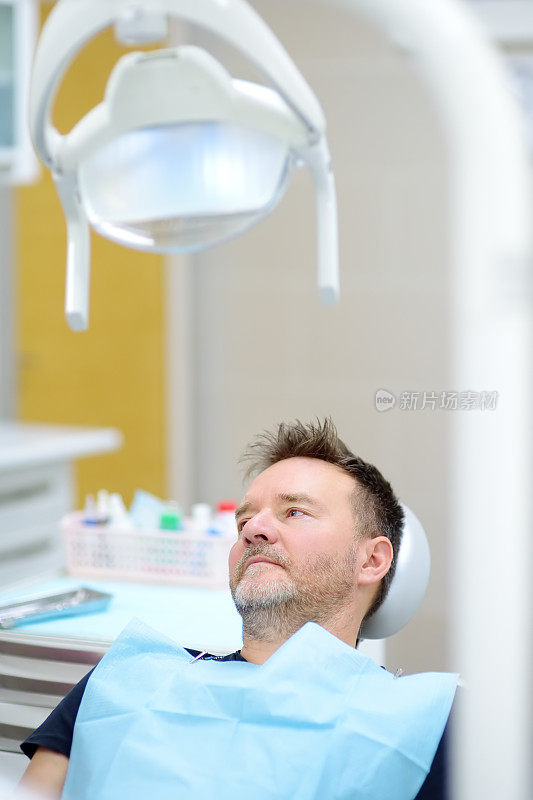 牙医诊室的病人。一个坐在医疗中心牙科椅上的成熟男人。牙科诊所医生预约