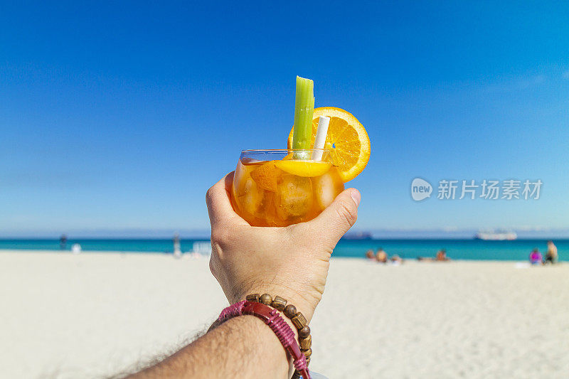 一名年轻的旅行男性在大西洋前享受他的假期，喝着鸡尾酒，在南海滩，迈阿密海滩，迈阿密，南佛罗里达，美国