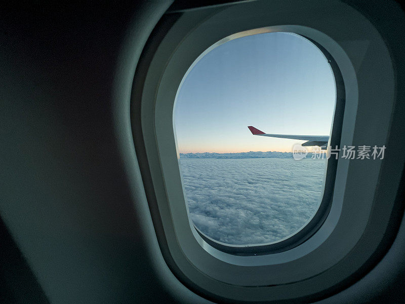 从飞机窗口往外看，美丽的日出在空中