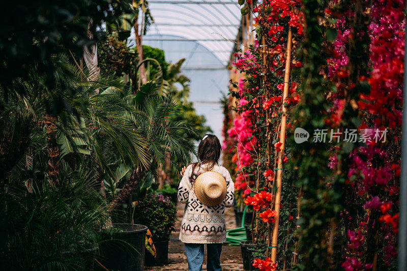 苗圃里九重葛的年轻女子