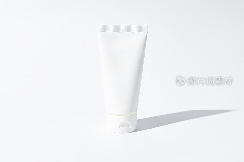 白色挤压瓶塑料管的模型，用于药品或化妆品的品牌-霜，凝胶，护肤品，牙膏。化妆品瓶子容器上的白色背景与阴影。极简主义