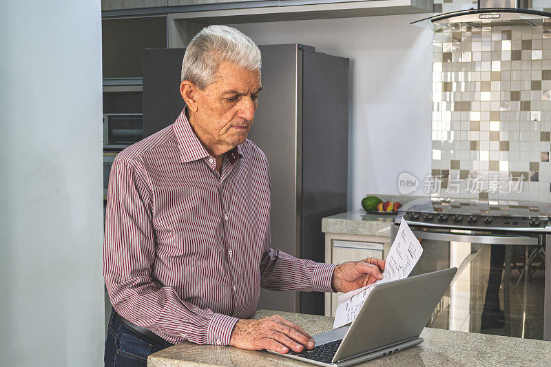 老年人在家使用笔记本电脑。