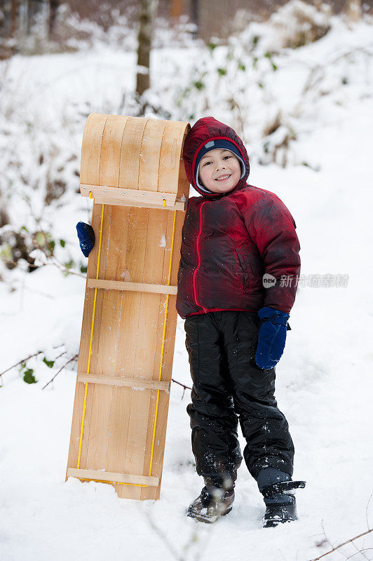 男孩在冬天拉雪橇