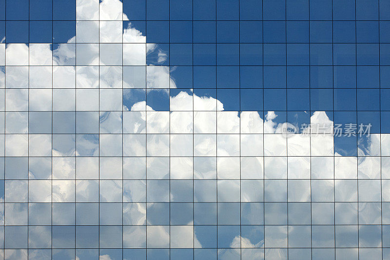 云朵映在现代办公大楼的窗户上