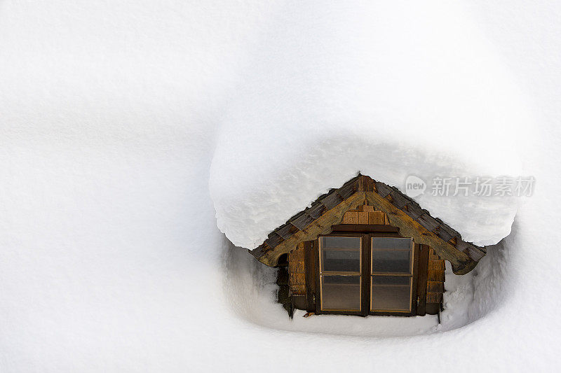 屋顶窗户被冬天的雪覆盖。保温概念