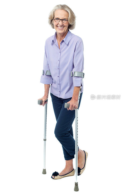 戴眼镜的老妇人拄着拐杖走路
