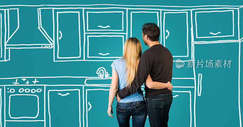 幸福的拥抱夫妇计划他们的家庭厨房装修。