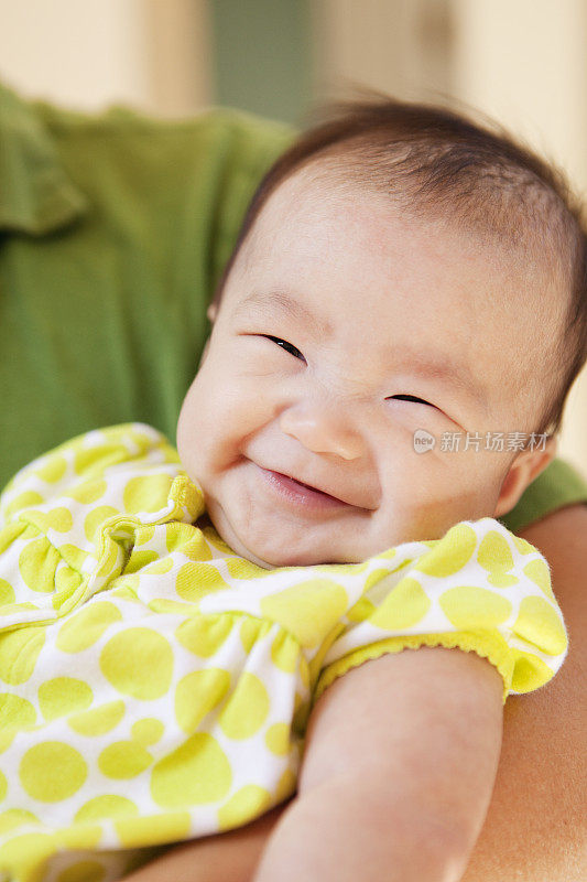 好哇，亚洲华人宝宝在父母的怀抱里微笑