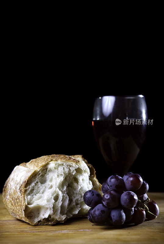 圣餐面包，葡萄酒，葡萄在黑色的背景