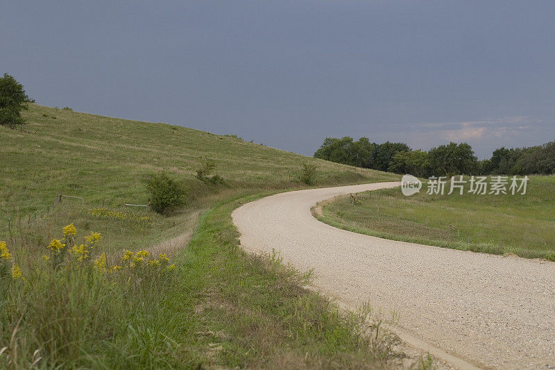 乡村的砾石路弯曲进入暴风雨的天空