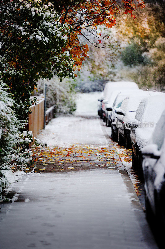 下雪的汽车停在秋天的城市里